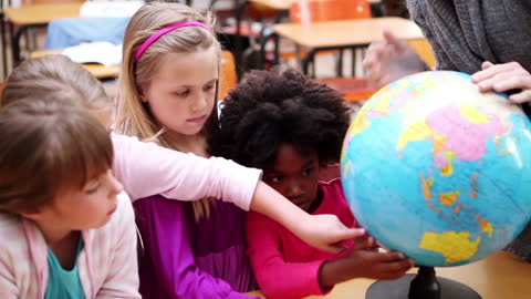 Curious Children Exploring Globe in Classroom Setting