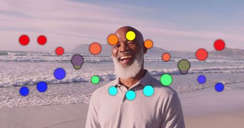 Smiling senior man on beach with abstract colorful circle overlay