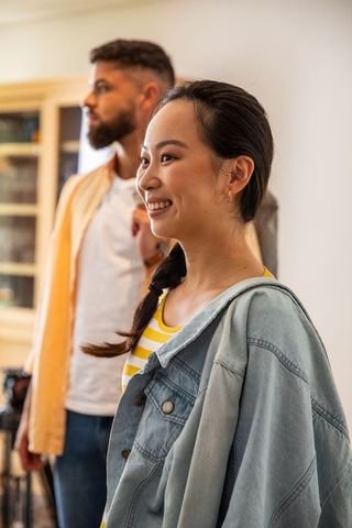 Couple Smiling Next to Shelf in Cozy Living Room