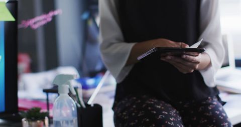 Woman Sanitizing Digital Tablet in Office Setting