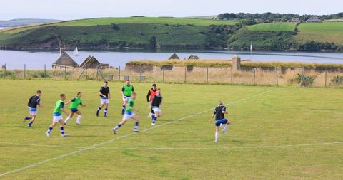 Athletes training in scenic coastal field with idyllic backdrop