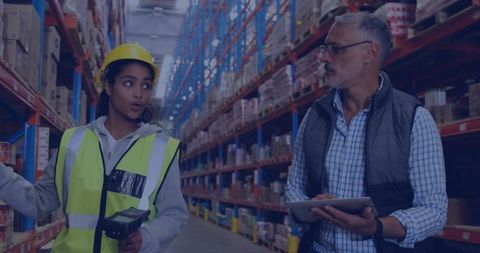 Hispanic woman scanning warehouse shelves while manager reviewing tablet for inventory