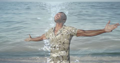 Man embracing ocean with open arms celebrating positive mindset