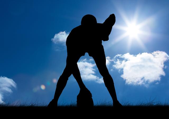 Silhouette of an athlete holding a rugby ball with bright sun and blue sky in the background. Perfect for topics on sportsmanship, outdoor activities, fitness, and athletic strength. Suitable for promotional materials, advertisements, or articles related to rugby and other outdoor sports.