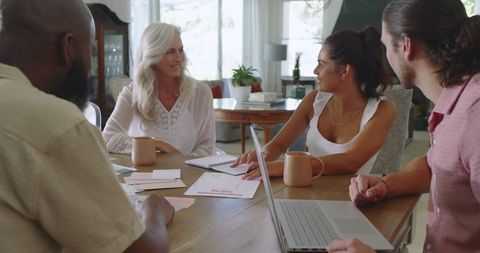 Diverse group collaborating on wedding plans at table