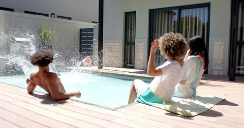 Diverse Friends Enjoying Relaxing Day by Luxurious Pool