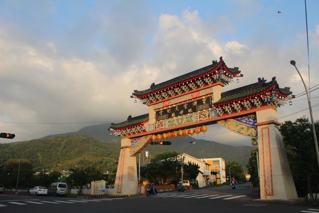 Traditional Chinese gate in serene mountain landscape with sunset. Ideal for travel and tourism brochures, cultural and heritage websites, architectural studies, and cityscape photo galleries.