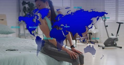 Woman sitting on bed holding lower back wearing smartwatch and teal tank with ar overlay