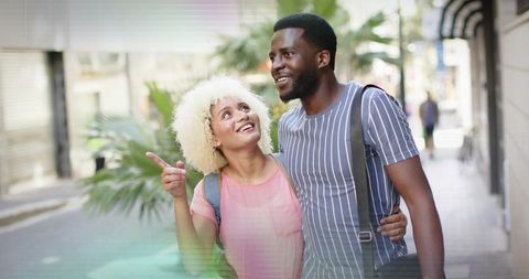 Interracial Couple Walking Embracing Amidst Urban Cityscape