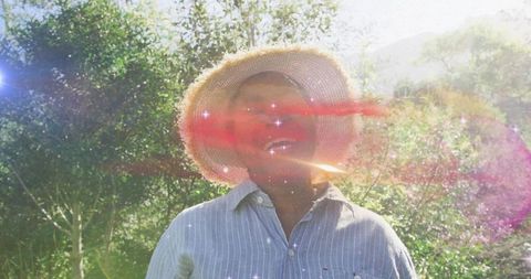 Smiling senior woman in orchard with sunhat
