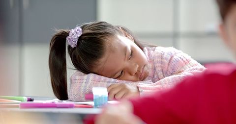 Young girl appearing bored during classroom session
