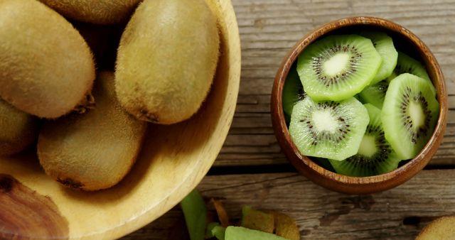 Close-up of slices and peel kiwi on wooden table