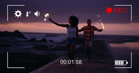 Couple enjoying fireworks on beach at night frame preview