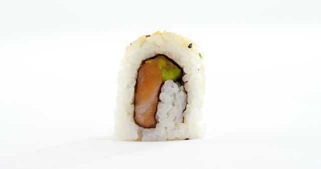 A single piece of sushi with rice, avocado, and fish is centered against a white background, with copy space. Its simplicity and the focus on the sushi roll make it ideal for menus or culinary presentations.