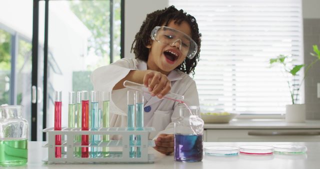 Curious boy wearing safety goggles and lab coat conducting chemistry experiment at home using test tubes filled with colorful liquids. Perfect for educational content, science and STEM promotions, or homeschooling resources.