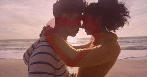 Romantic couple embracing at beach with heart overlay