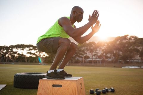 Man Practicing Box Jumps with Mask During Outdoor Workout