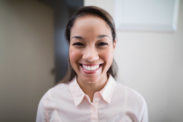 Young female physiotherapist smiling in hospital ward. Ideal for healthcare, medical, and wellness-related content. Useful for promoting patient care, therapy services, and professional healthcare environments.