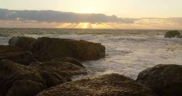 Sunset beams over a rocky shoreline, with copy space - Download Free Stock Photos Pikwizard.com