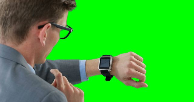 Businessman Checking Smartwatch on Green Background - Download Free Stock Images Pikwizard.com