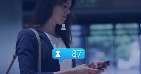 Businesswoman Engaging with Smartphone Notifications in Modern Lobby