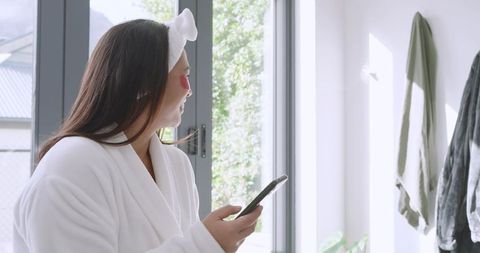 Woman enjoying skincare routine by sunlit window