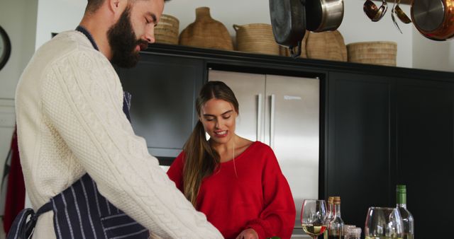 Image of happy caucasian couple cooking and drinking wine. Domestic lifestyle and leisure at home.
