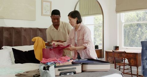 Couple Preparing Suitcase for Vacation in Cozy Bedroom