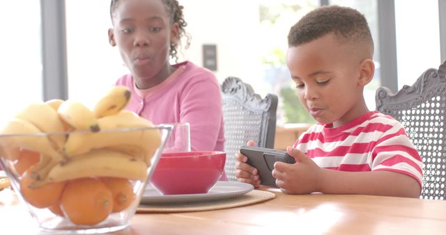 Young Boy Using Smartphone While Having Breakfast With Mother - Download Free Stock Images Pikwizard.com