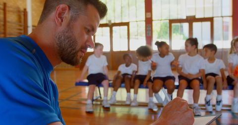 Basketball coach planning strategy in a school gym