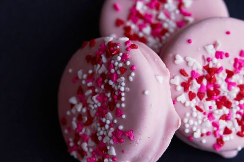 Pink heart sprinkled cookies on black background