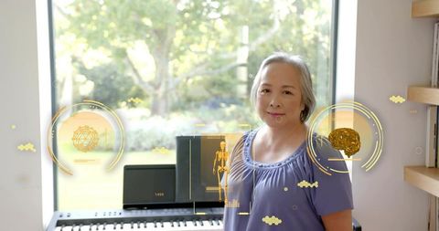 Senior woman standing at keyboard playing piano with golden neural and skeletal tech overlays