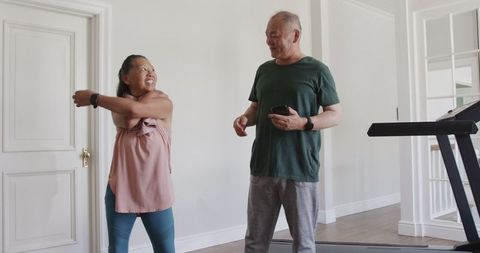 Senior couple enjoying post-workout laughter in home gym
