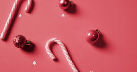 Festive Arrangement of Candy Canes and Christmas Ornaments on Red Background - Download Free Stock Images Pikwizard.com