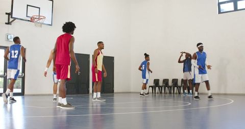 Diverse Basketball Players on Indoor Court Wearing Team Jerseys
