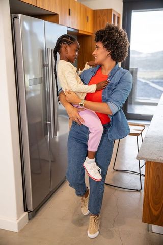 Mother and Daughter Smiling in Modern Kitchen Interior