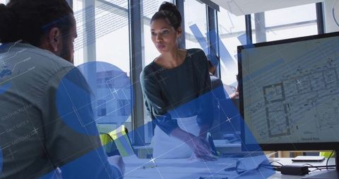 Architect Leading Team Pointing at Blueprints and Digital Floorplan on Monitor
