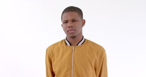 Young man contemplating in mustard jacket