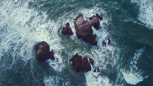 Top Aerial View of Waves Crashing on Rocks in Ocean - Download Free Stock Photos Pikwizard.com