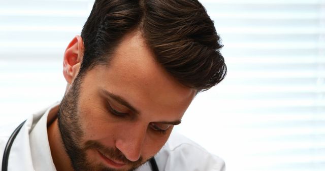 Young Male Doctor Concentrating on Work while Writing - Download Free Stock Images Pikwizard.com