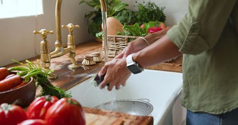 Woman Washing Fresh Produce in Rustic Kitchen Sink