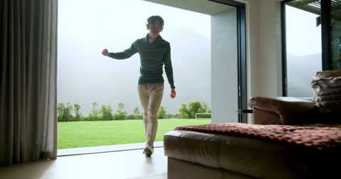 Young Adult Near Sliding Glass Door Enjoys Dancing to Music