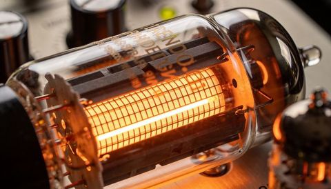 Vintage vacuum tube amplifier glowing orange filament macro detail on metal chassis