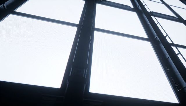 Frosted skylight panels and steel support grid in industrial warehouse ceiling with ladder