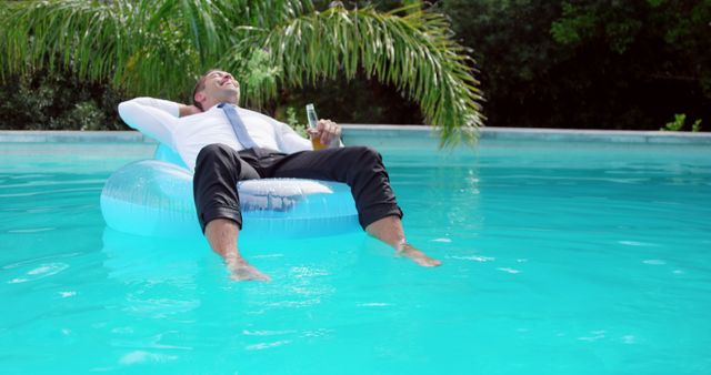 Businessman Relaxing with Drink on Pool Float in Tropical Setting - Download Free Stock Images Pikwizard.com