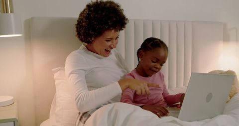 Mother and Daughter Bonding Time with Laptop on Bed