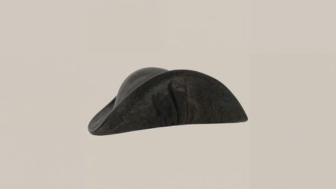 Vintage Black Tricorne Hat on Beige Background with Artistic Shadow