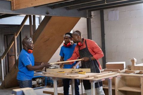 African american carpenters assembling cabinets at workbench in rustic woodworking workshop