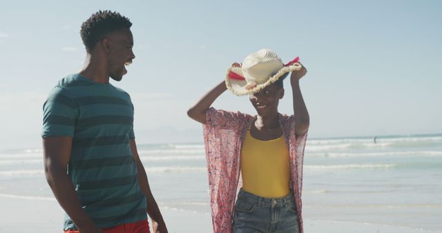 Young Couple Having Fun on Beach with Hat - Download Free Stock Images Pikwizard.com