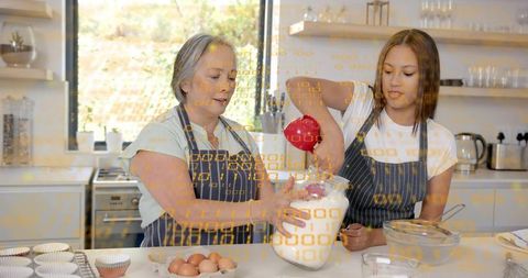 Mother and daughter pouring flour while baking in sunlit kitchen with striped aprons
